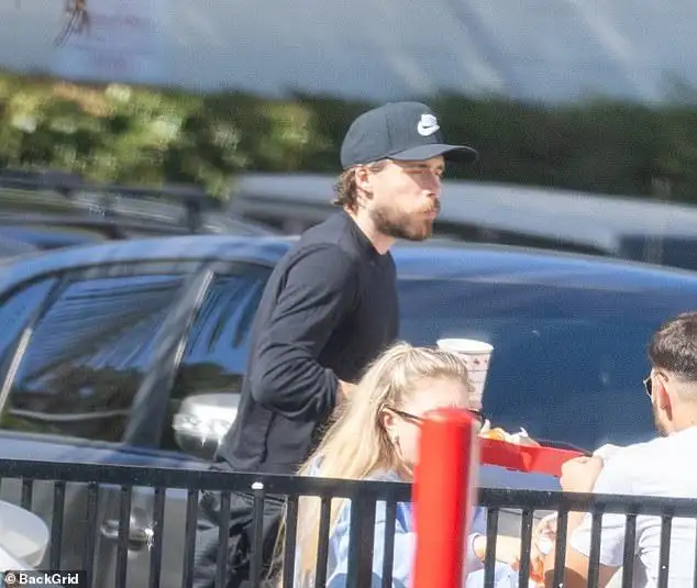 Table for one: Brooklyn Beckham cuts a solitary figure as he dines alone at a fast food restaurant as his family put on a united front at lavish events in New York - 4