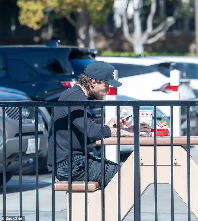 Table for one: Brooklyn Beckham cuts a solitary figure as he dines alone at a fast food restaurant as his family put on a united front at lavish events in New York - 1